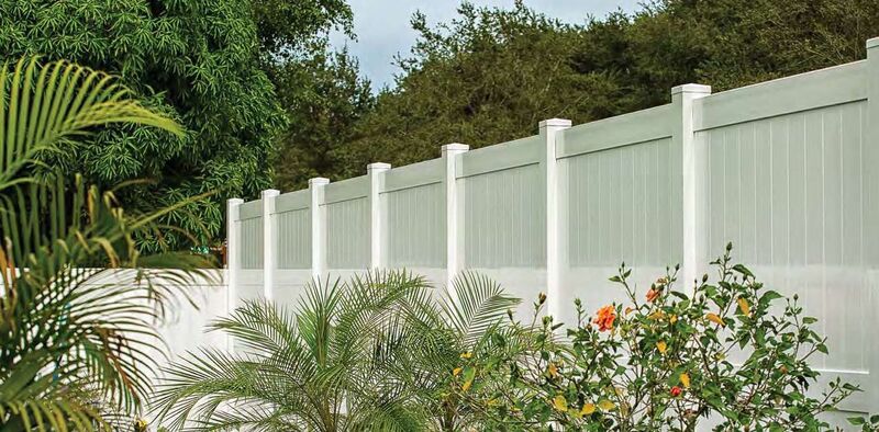 White vinyl privacy fence stepping up a slope