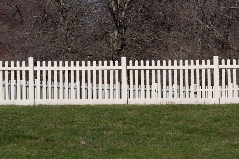 White vinyl picket fence with three-inch spacing and a two-by-six bottom rail