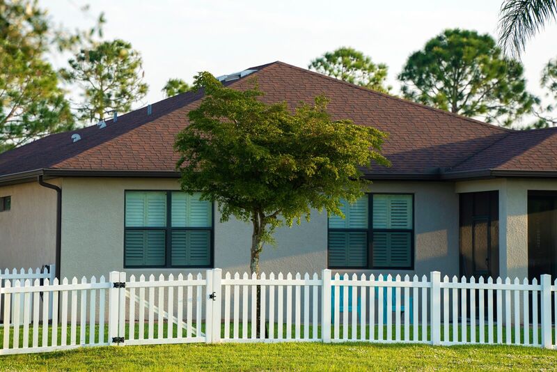 White vinyl four-foot straight picket fence and gate in front of a stucco home