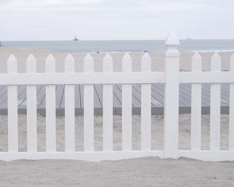 White vinyl picket fence on a beach boardwalk