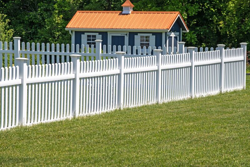 White vinyl narrow-gap picket fence with ball post caps enclosing a yard with a shed