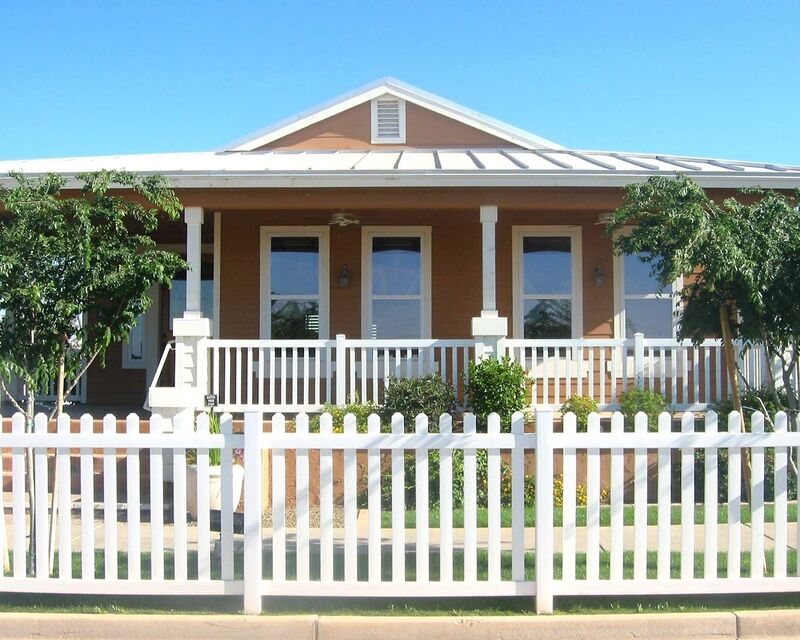 White vinyl straight picket fence in front of a cottage porch