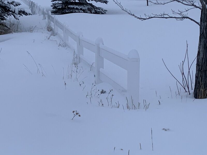 White vinyl two-rail ranch fence in deep snow