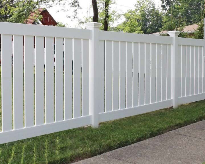 White vinyl closed picket semi-privacy fence along a sidewalk