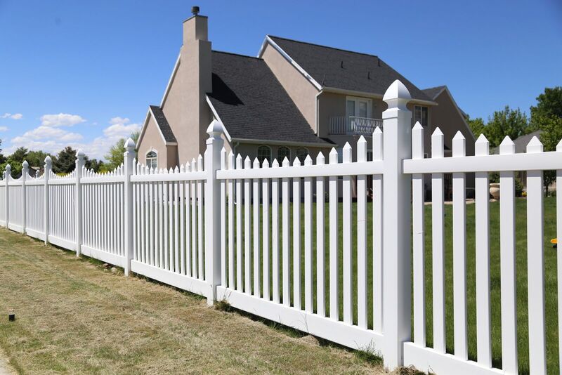 White vinyl picket fence in a front yard