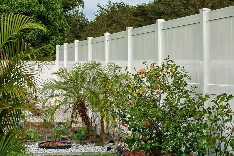Eight-foot white vinyl privacy fence enclosing a backyard